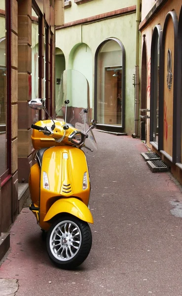 Küçük bir sokakta sarı moped