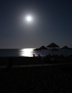 Gece sahilde bir dolunay altında