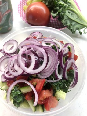 Sağlıklı sebze salatası taze domates, salatalık, soğan, ıspanak, tabakta marul. Diyet menüsü. Üst Manzara. Yemek fotoğrafı.