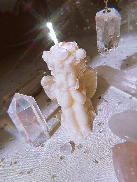 小さなかわいい天使の形をした白いキャンドルろうそくの横には水晶の結晶があります — ストック写真