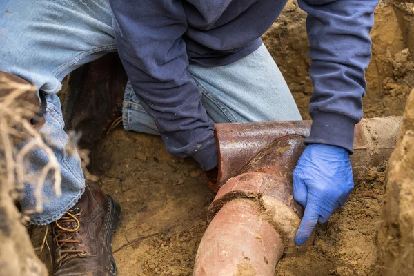 Klempner gräbt verstopfte Abwasserleitung aus — Stockfoto