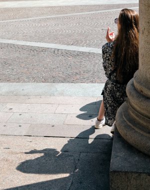 Milano 'da gölgesinde sigara içen yalnız moda kızı Lombardiya İtalya' da