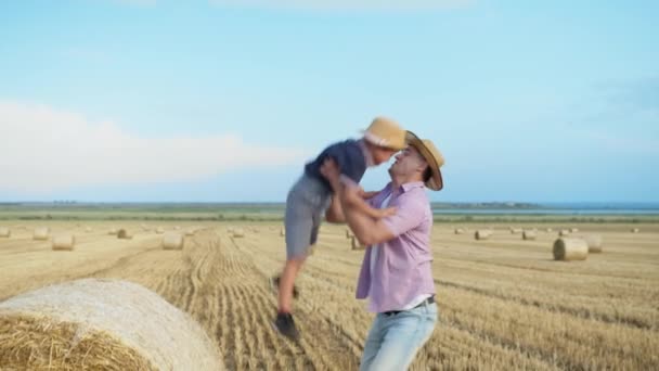 幸せな家族や子供たちは干し草から父の手に飛び込み — ストック動画