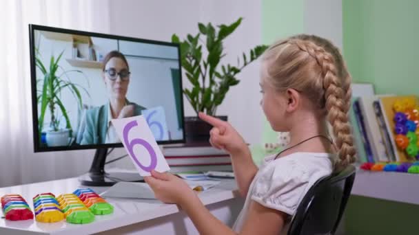 Enfants enseignement à distance, écolière montre des cartes avec des chiffres pendant la leçon de mathématiques pour l'enseignant à l'écran d'ordinateur à la maison — Video