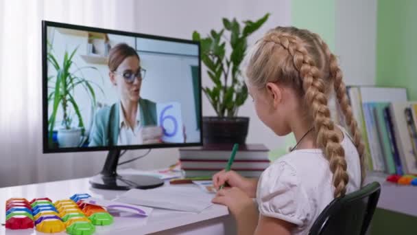 Ensino à distância durante pandemia, estudante estudando matemática com sua professora sentada em casa com computador — Vídeo de Stock