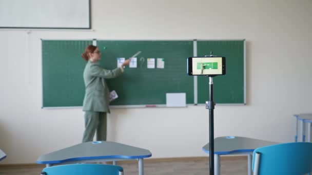 Educație matematică on-line, profesor cu carduri lângă tablă folosind camera video de telefon mobil înregistrându-se la lecție la școală — Videoclip de stoc