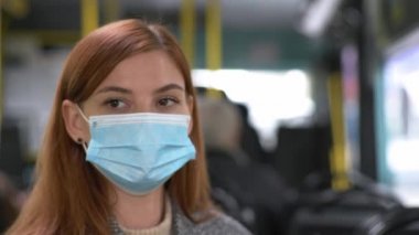 Sağlığı kötü olan ve öksüren tıbbi maskesi ve eldivenleri olan bir kadın toplu taşıma araçlarında seyahat ederken kamu alanlarında modern güvenlik önlemlerini uyguluyor.