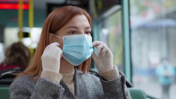 Jonge vrouw doet haar medische masker af tijdens het reizen met het openbaar vervoer en kijkt uit het raam met een glimlach, quarantaine — Stockvideo