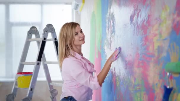 Artista chica jugando con colores en casa durante la renovación, feliz joven mujer con coloridas palmas pintadas — Vídeo de stock
