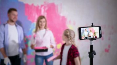 vloglama, fırça ve roller ile aile akıllı telefon kamerasında yenileme sırasında duvarların nasıl boyandığını videoya çekiyor