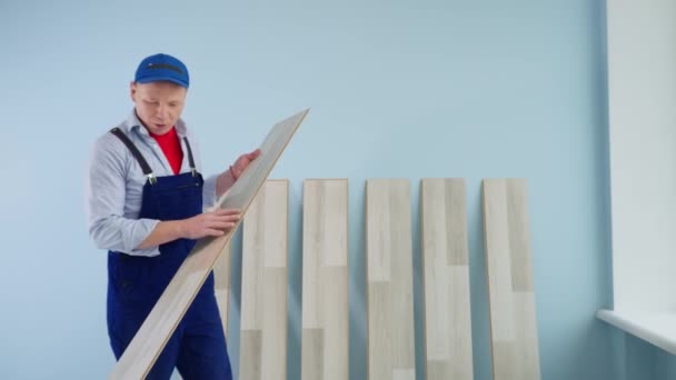 Der Meister zeigt das Laminat und erzählt mit der Handykamera von Installation, Videoblog und Renovierung — Stockvideo