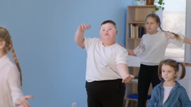 Estilo de vida activo, niño con sobrepeso con síndrome de Down bailando con un grupo de niños sanos durante la lección de baile — Vídeo de stock