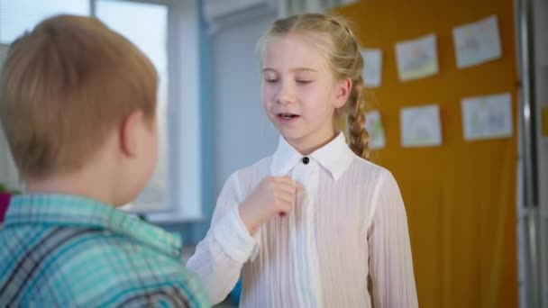 Retrato de chica con frenos muestra niño signo de niño te amo y luego abrazos, hermano y hermana relación — Vídeos de Stock