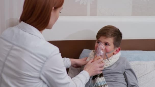 Mãe ajuda a criança do sexo masculino com saúde ruim respirar nebulizador durante a doença e tratamento em casa — Vídeo de Stock