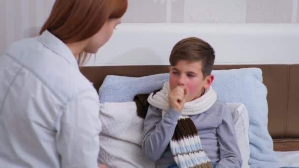 Matka bude měřit tělesnou teplotu v Celsia nezdravému mužskému dítěti s bezkontaktním teploměrem, malý chlapec si stěžuje rodičce na špatné zdraví — Stock video