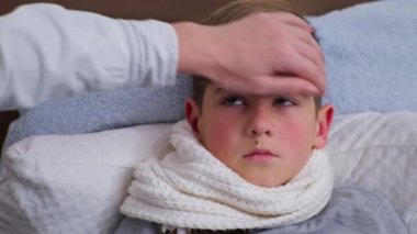 Kadın ebeveyn Fahrenheit 'te vücut ısısını ölçer. Temas olmayan termometreyle düşük sağlık ve koronavirüs belirtileri gösterir.