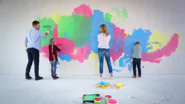 Ženatý dědeček s dcerou a synem se syndromem šťastně malovat stěnu v různých barvách spolu v pokoji během rekonstrukce, terapie dítě — Stock video