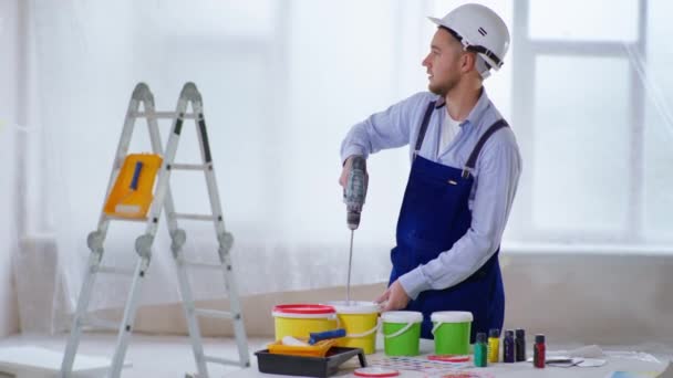 Especialista en construcción masculina mezcla el color de la pintura del mezclador de construcción eléctrica para la pintura de pared haciendo renovaciones — Vídeo de stock