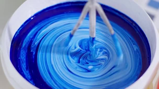 Mixing building materials for painting walls, worker mixes blue and white paint in bucket with whisk and drill to renovate room — Stock Video