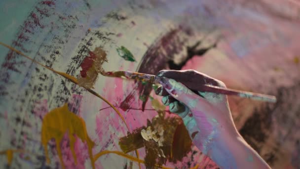 Δημιουργική ατμόσφαιρα, τα χέρια καλλιτέχνη βάφονται με χρώματα γκρο πλαν ζωγραφίσει μια εικόνα σε καμβά με ένα πινέλο στο εργαστήριο — Αρχείο Βίντεο