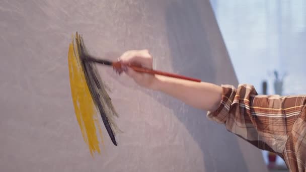 Κοντινό πλάνο του κοριτσιού χέρι με ένα πινέλο αντλεί με χρώματα σε ένα μεγάλο καμβά, σύγχρονη δημιουργική διαδικασία σε αργή κίνηση — Αρχείο Βίντεο
