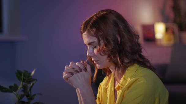 Vrouwelijke christen met hoop en geloof in haar hart bidt met gevouwen handen tot geliefde God tijdens het avondgebed voor het slapengaan in de kamer — Stockvideo