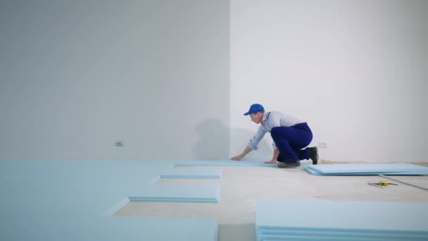 Construtor masculino profissional executa trabalhos de construção isola piso com espuma de poliuretano antes de colocar laminado dentro de casa — Vídeo de Stock