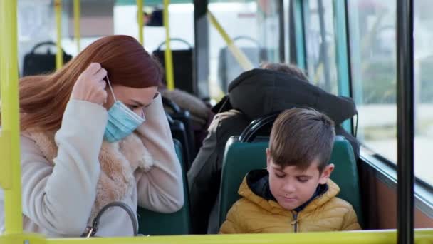 Woman and little boy take precautions and put on medical masks to protect against virus and coronavirus infection, then give each other five — Stock Video