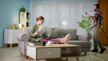 Ceketli ve pijama pantolonlu kadın çalışanlar, kulaklıklı adam odaları süpürürken bilgisayar konuşmalarındaki modern teknoloji ve uygulamaları uzaktan kumanda ederek çalışıyor.