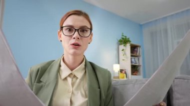 Karantinaya alınan kadın ofis çalışanı, erkek odayı süpürürken video konferansında dizüstü bilgisayarla konuşuyor.