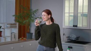 Gözlüklü kızın portresi mutfaktaki camdan mikro yeşil smoothie iç, diyetteki mutlu genç kadın.