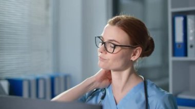 Doktor çalışırken boynundaki acıyı hisseder, beyaz kadın sağlık görevlisi mavi üniformalı adam kameraya yakından bakar.