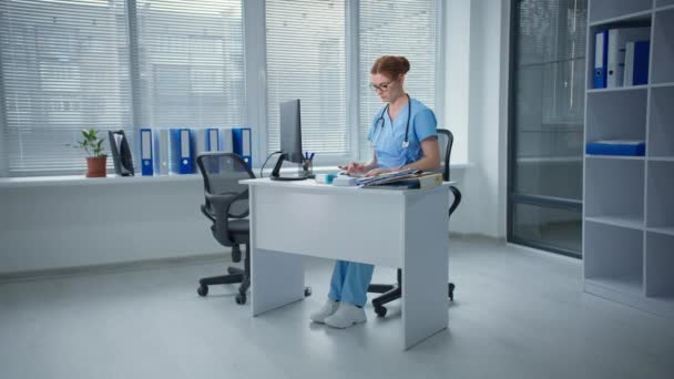 Πονόλαιμος, αναστατωμένος γυναίκα γιατρός εργάζεται σε έναν υπολογιστή στη συνέχεια, αγγίζοντας το λαιμό με τα δάχτυλά της στο γραφείο του νοσοκομείου — Αρχείο Βίντεο
