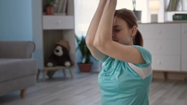 Spor giyimli bir kadın, karantinadaki gaz odasında aktif fitness yaptıktan sonra meditasyon yapıyor.