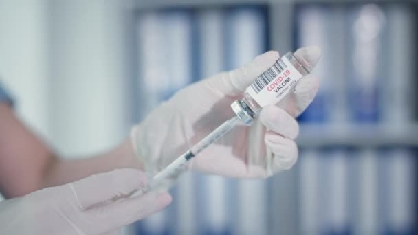 Vaccination, doctor filling syringe with vaccine, closeup hands of physician in protective gloves — Stock Video