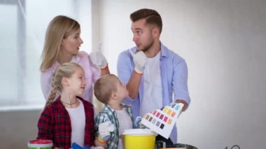 Down sendromlu arkadaş canlısı bir aile ve kız kardeşi yenileme ve resim işleri sırasında duvarları boyamayı seçiyor.