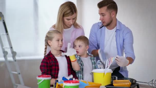 Homem e mulher com síndrome de Down menino e menina escolher pintura de parede da paleta de cores durante renovações interiores e decoração — Vídeo de Stock