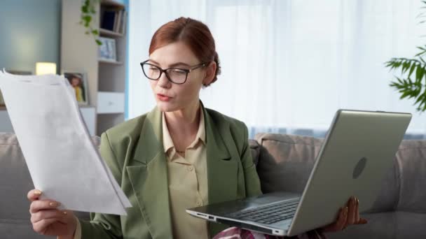 Freelance donna che lavora a casa ufficio da remoto e comunicare con il cliente tramite video comunicazione sul computer portatile mentre seduto a casa ana divano — Video Stock