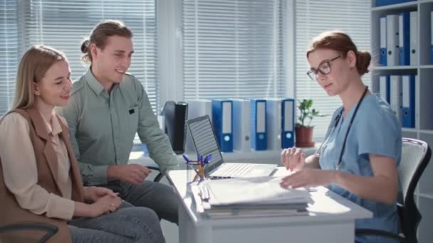 Pareja casada disfrutando de buenas pruebas durante la consulta con el médico en la oficina del hospital — Vídeos de Stock