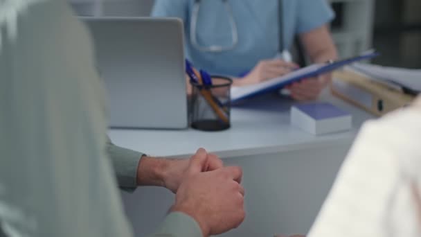 Couple marié lors d'un rendez-vous chez le médecin discuter de l'état de santé au bureau de l'hôpital, mains gros plan — Video