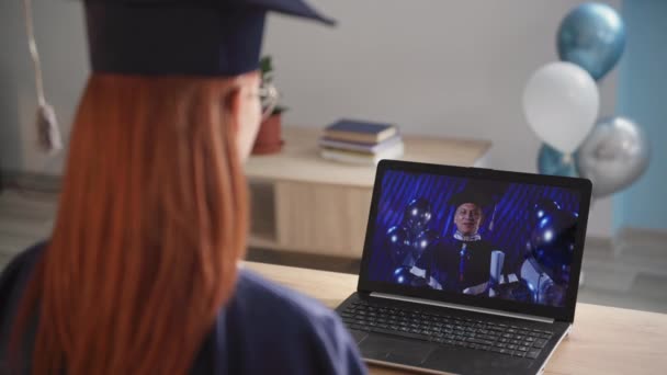 Studente donna in mantello accademico alla laurea remota tramite collegamento video portatile durante l'istruzione remota, primo piano — Video Stock