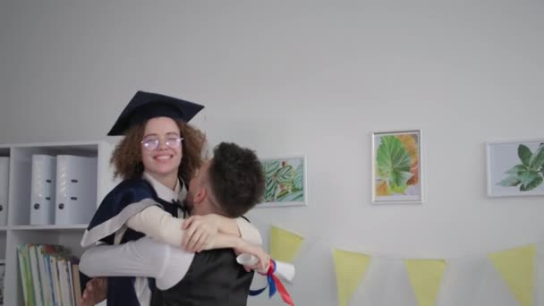 Happy girl university graduate jumping into arms of guy rejoicing at training certificate — Wideo stockowe