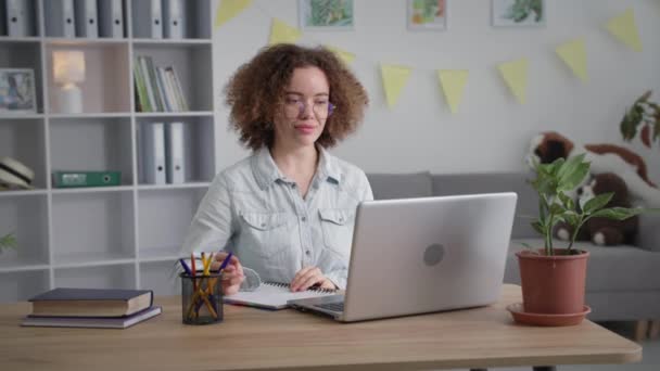 Дистанционное обучение, молодая женщина на конференции онлайн общается с помощью видеосвязи на ноутбуке — стоковое видео
