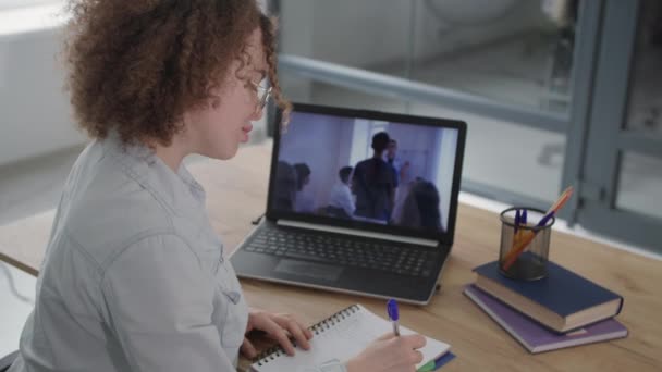 Онлайн-образование, очаровательная молодая женщина проходит дистанционное обучение с использованием современных видеокоммуникационных технологий на ноутбуке — стоковое видео