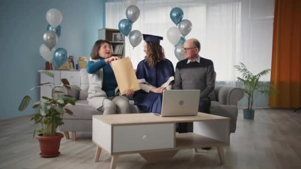 Pais felizes, juntamente com sua filha pós-graduação estão felizes em receber diploma e pós-graduação da universidade — Vídeo de Stock