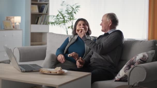Idős szerető párok élvezik a közös kikapcsolódást és szendvicsekkel etetik egymást. — Stock videók
