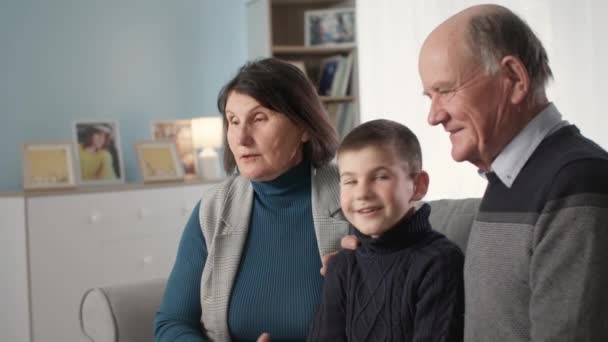 Loving elderly woman and man with their beloved grandson have fun enjoying a joint vacation and communication at home — Αρχείο Βίντεο