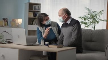 modern medicine, old spouses in medical masks at medical consultation online talk on video call with doctor at home