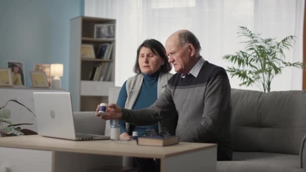 Погане здоров'я, літній чоловік і жінка консультуються з лікарем через відеозв'язок на ноутбуці — стокове відео