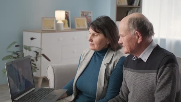 Чоловіки і жінки-пенсіонери на медичній консультації розмовляють на веб-камеру з лікарем про стан здоров'я, що сидить вдома — стокове відео